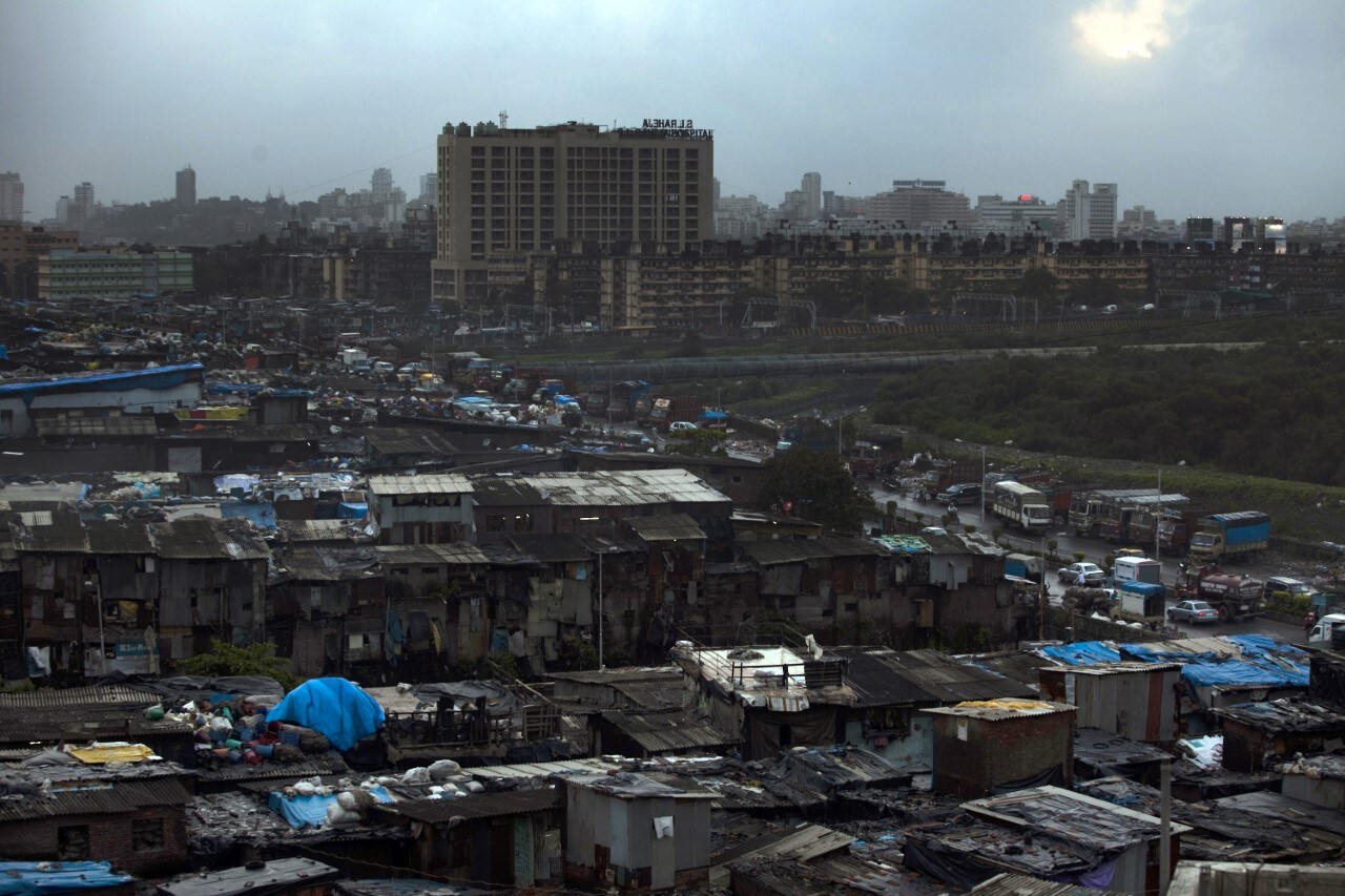The Bandra Kurla Complex rises in the background, behind the slum dwellings of Dharavi, in Mumbai. (Photographer: Prashanth Vishwanathan/Bloomberg)